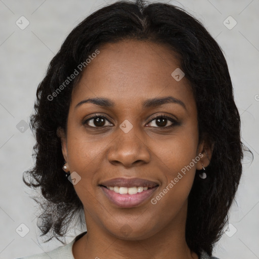 Joyful black young-adult female with long  black hair and brown eyes