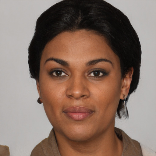 Joyful black young-adult female with short  black hair and brown eyes