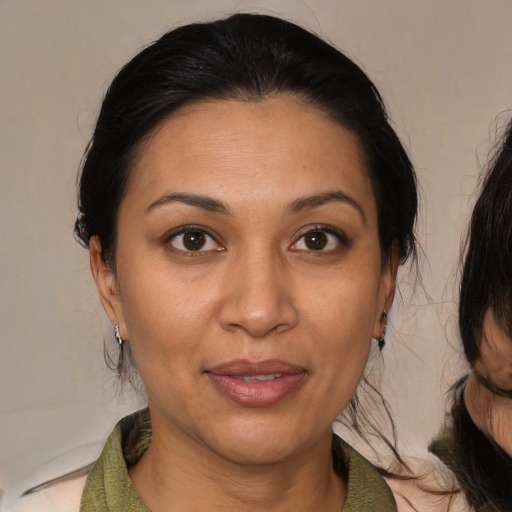 Joyful latino adult female with medium  brown hair and brown eyes