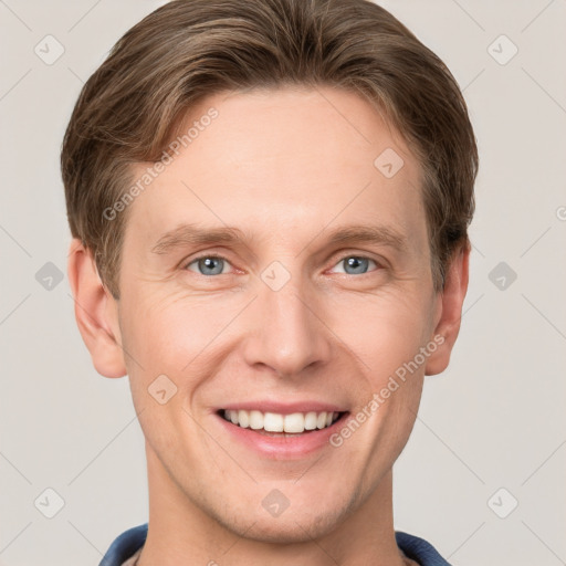 Joyful white young-adult male with short  brown hair and grey eyes