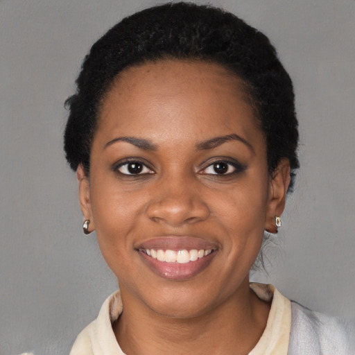 Joyful black young-adult female with short  black hair and brown eyes
