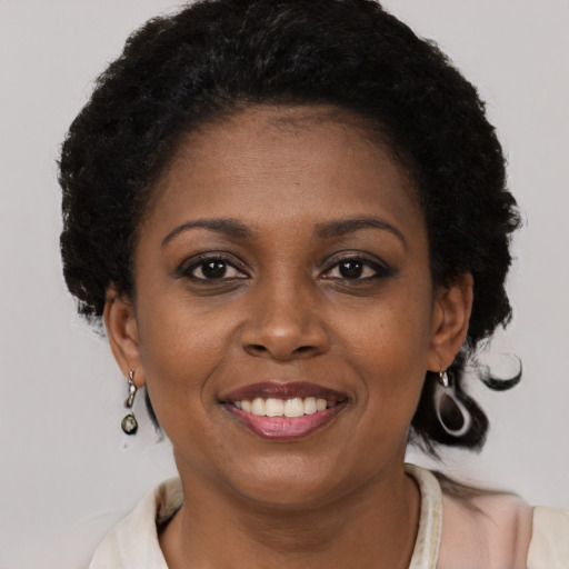 Joyful black young-adult female with short  brown hair and brown eyes