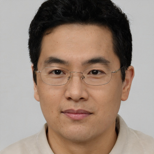 Joyful asian adult male with short  black hair and brown eyes