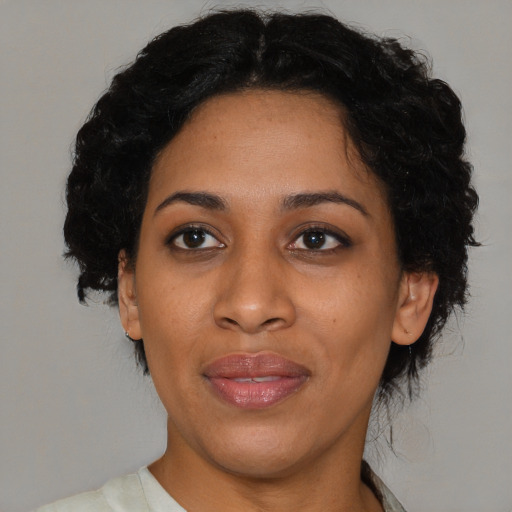 Joyful black adult female with medium  black hair and brown eyes