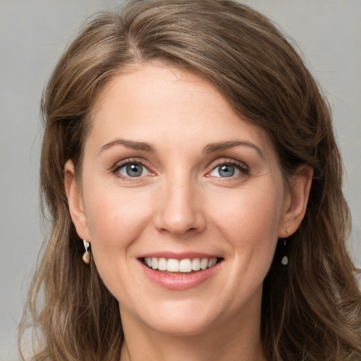 Joyful white young-adult female with long  brown hair and grey eyes