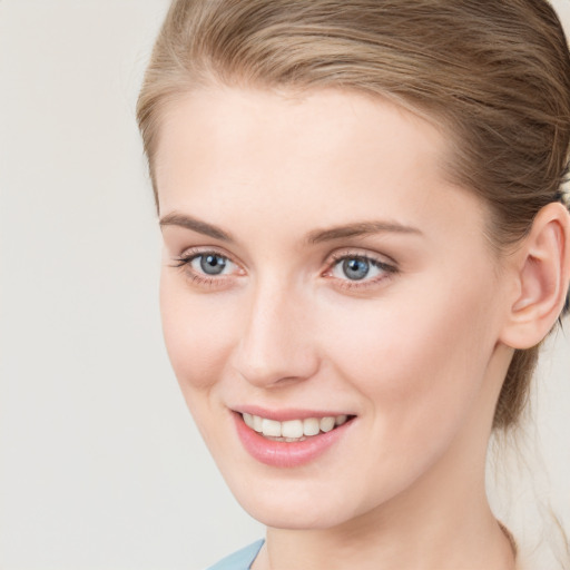 Joyful white young-adult female with medium  brown hair and blue eyes