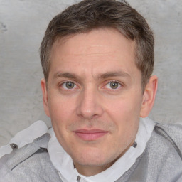 Joyful white adult male with short  brown hair and blue eyes