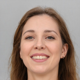 Joyful white young-adult female with long  brown hair and grey eyes