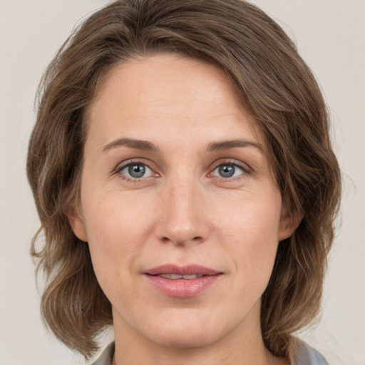 Joyful white adult female with medium  brown hair and green eyes