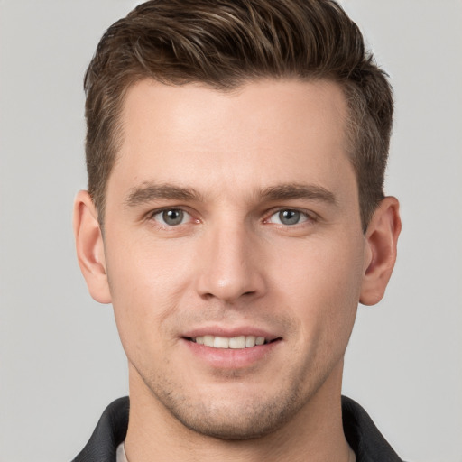 Joyful white young-adult male with short  brown hair and grey eyes