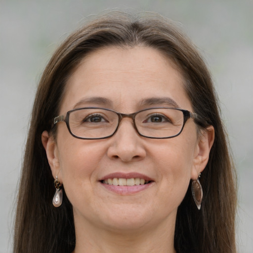 Joyful white adult female with long  brown hair and grey eyes