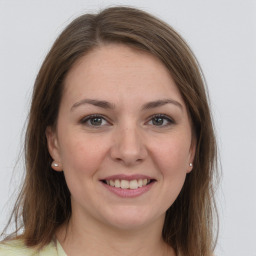 Joyful white young-adult female with long  brown hair and grey eyes