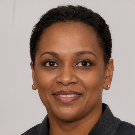 Joyful black adult female with short  black hair and brown eyes