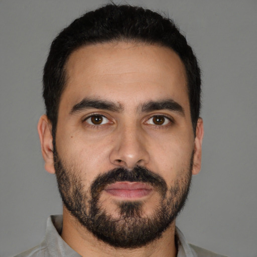 Joyful latino young-adult male with short  black hair and brown eyes
