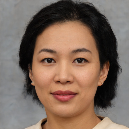 Joyful asian adult female with medium  black hair and brown eyes