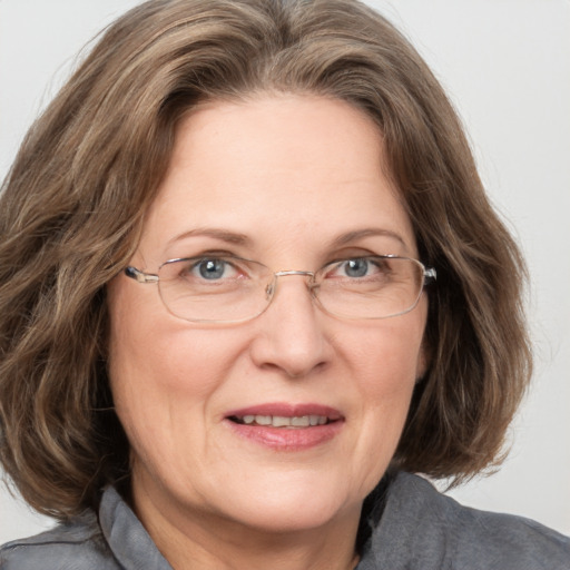 Joyful white middle-aged female with medium  brown hair and blue eyes