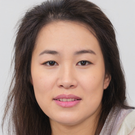 Joyful asian young-adult female with long  brown hair and brown eyes