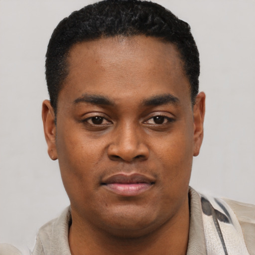 Joyful black young-adult male with short  black hair and brown eyes