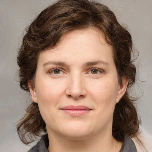 Joyful white young-adult female with medium  brown hair and blue eyes