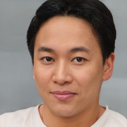 Joyful asian young-adult male with short  brown hair and brown eyes