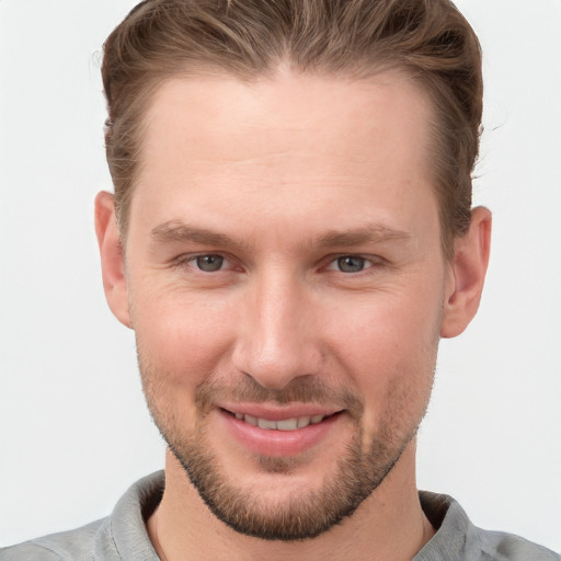 Joyful white young-adult male with short  brown hair and grey eyes