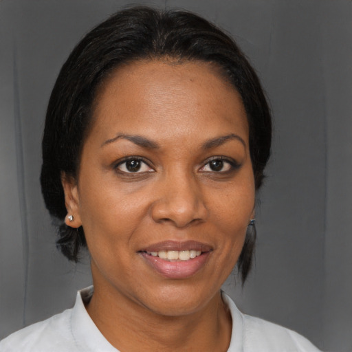 Joyful black adult female with medium  brown hair and brown eyes