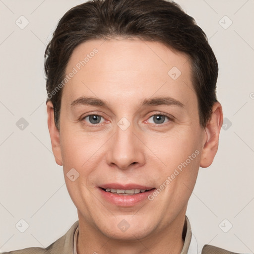 Joyful white young-adult male with short  brown hair and grey eyes