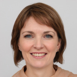 Joyful white young-adult female with medium  brown hair and grey eyes