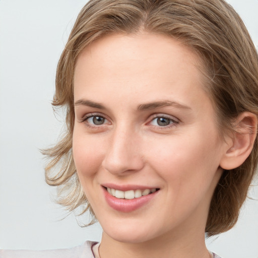 Joyful white young-adult female with medium  brown hair and blue eyes