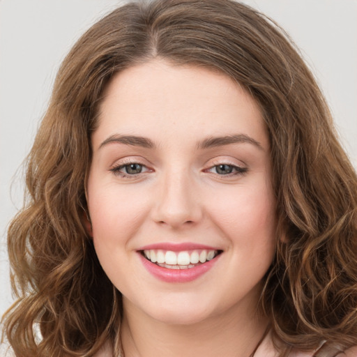 Joyful white young-adult female with long  brown hair and green eyes