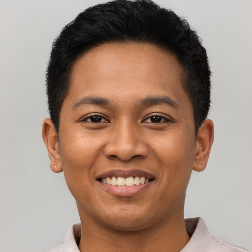 Joyful latino young-adult male with short  brown hair and brown eyes