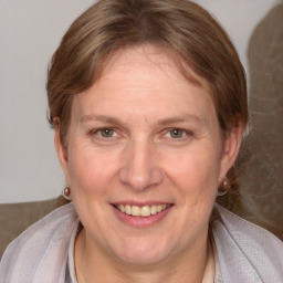 Joyful white adult female with medium  brown hair and blue eyes