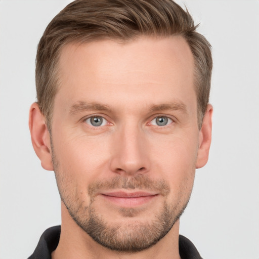 Joyful white young-adult male with short  brown hair and grey eyes