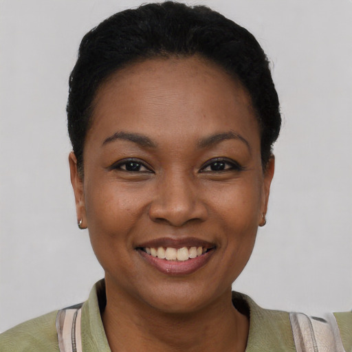 Joyful black young-adult female with short  black hair and brown eyes