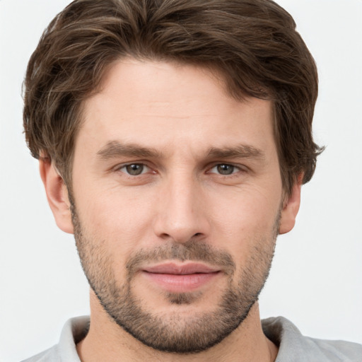 Joyful white young-adult male with short  brown hair and grey eyes