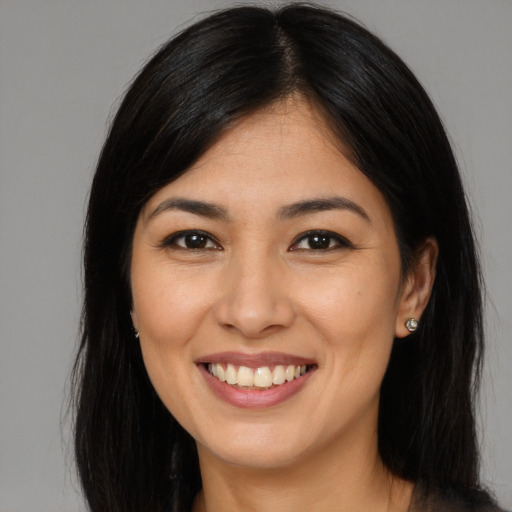 Joyful asian young-adult female with long  brown hair and brown eyes