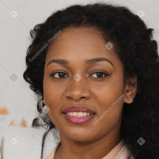 Joyful black adult female with long  brown hair and brown eyes