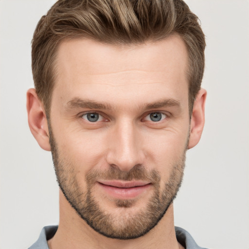 Joyful white young-adult male with short  brown hair and grey eyes