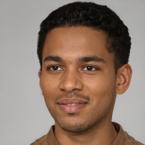 Joyful black young-adult male with short  brown hair and brown eyes