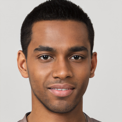 Joyful black young-adult male with short  brown hair and brown eyes