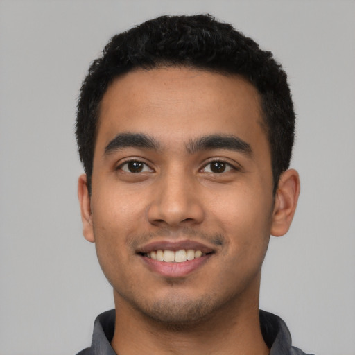 Joyful latino young-adult male with short  black hair and brown eyes