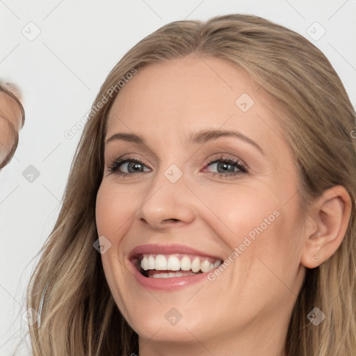 Joyful white young-adult female with long  brown hair and brown eyes