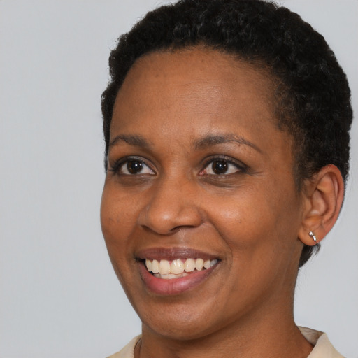 Joyful black adult female with short  brown hair and brown eyes