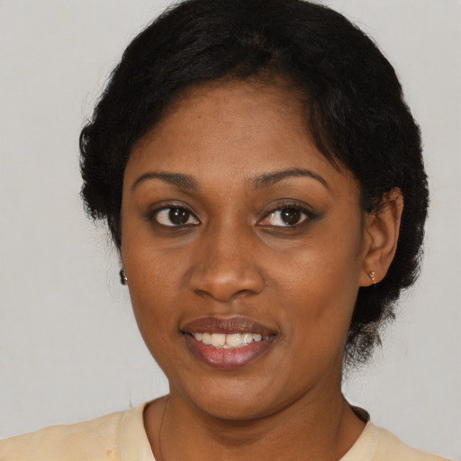 Joyful black adult female with short  black hair and brown eyes