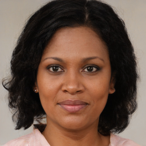 Joyful black adult female with medium  brown hair and brown eyes