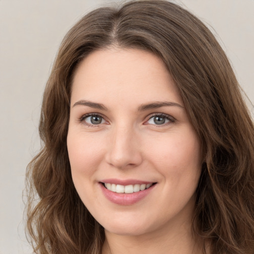 Joyful white young-adult female with long  brown hair and green eyes