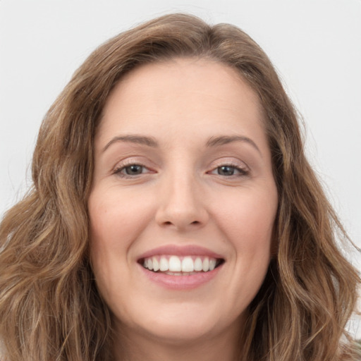 Joyful white young-adult female with long  brown hair and green eyes