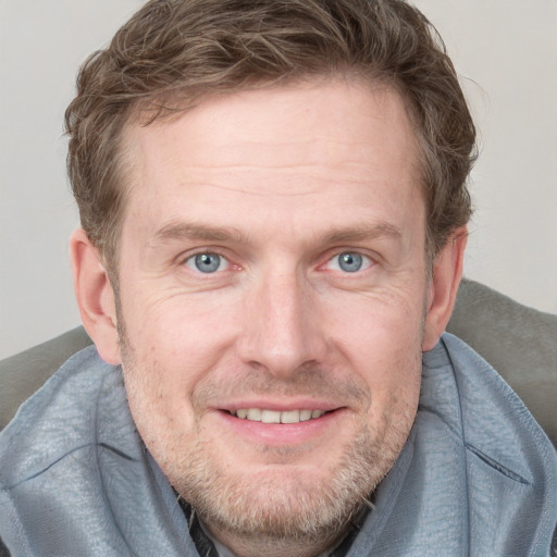 Joyful white adult male with short  brown hair and blue eyes