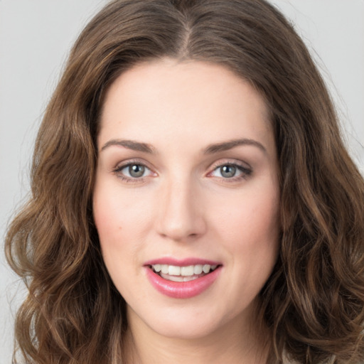 Joyful white young-adult female with long  brown hair and green eyes