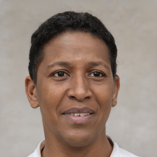 Joyful black young-adult female with short  black hair and brown eyes